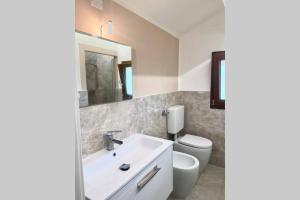 łazienka z białą umywalką i toaletą w obiekcie La casa al mare di Luca w mieście Bellaria-Igea Marina