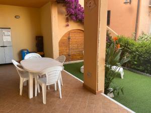 un tavolo bianco e sedie su un patio con porta di Casa Mayo a Olbia