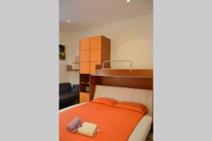 1 dormitorio con 1 cama con manta naranja en Letto ad acqua H2OME, en Bari