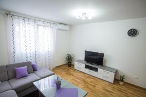 sala de estar con sofá y TV en Too Sweet Apartment 1, en Split