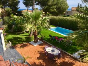 un cortile con piscina e palma di L'ESCALE COTE BLEUE B&B AND Spa a Sausset-les-Pins