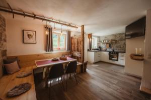 una cucina e una sala da pranzo con tavolo e sedie di Chalet Passeier - RIVER a Saltusio
