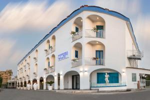 un gran edificio blanco con balcones y una estatua en Hotel Poseidonia Mare, en Paestum