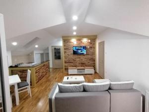 a living room with a couch and a kitchen at Duh Zlatara in Nova Varoš
