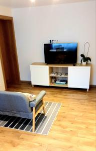 ein Wohnzimmer mit einem TV auf einem weißen Schrank in der Unterkunft KANTO - self check in in Klaipėda