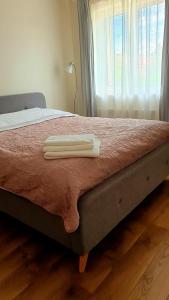 a bed with two white towels on top of it at KANTO - self check in in Klaipėda