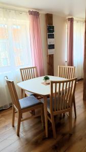a dining room table with four chairs and a white table at KANTO - self check in in Klaipėda