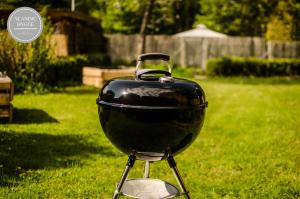 a black grill sitting in the grass in a yard at Ferienwohnung Scandic Hygge Bevern im Weserbergland in Bevern