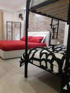 a bedroom with two beds with red pillows at Maison Marguerite in Margherita di Savoia