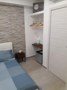 a bedroom with a bed and a clock on a brick wall at Maison Marguerite in Margherita di Savoia +66 photos