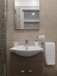 bagno con lavandino bianco e specchio di Maison Marguerite a Margherita di Savoia