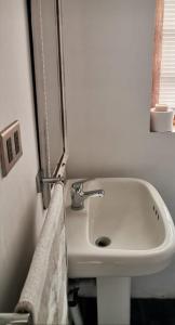 baño con lavabo blanco y toalla en Casa Wilson en Zapallar