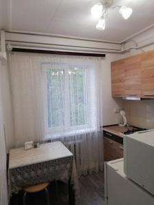 una pequeña cocina con mesa y ventana en Аренда квартиры, en Izmaíl