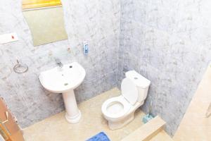 a bathroom with a toilet and a sink at Covenant Hotel in Accra