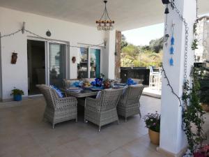 ein Esszimmer mit Tisch und Korbstühlen in der Unterkunft Villa Priene - Gumusluk Private Pool in Gümüşlük