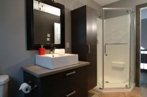 a bathroom with a white sink and a shower at 14- Chalet à louer à Stoneham in Stoneham +21 photos