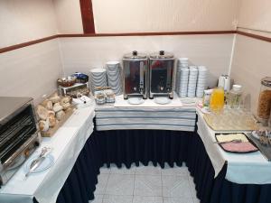 a room with a table with food and drinks on it at Hotel Palmeira in Aveiro