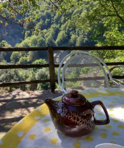 a tea kettle sitting on a table with a chair at Guest House Ktona in Dardhë