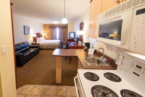 a hotel room with a kitchen and a living room at Days Inn by Wyndham Bonnyville in Bonnyville