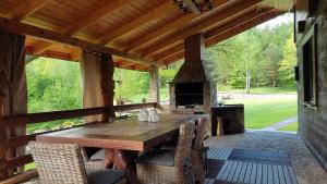 a patio with a wooden table and a fireplace at DOMEK POD DĘBEM in Mielnik