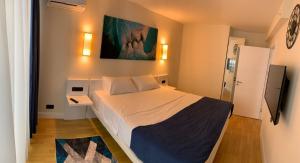a bedroom with a bed and a painting on the wall at orbi city elit class suıt in Batumi +19 photos