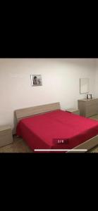 um quarto com uma cama vermelha e um cobertor vermelho em Casavacanza David em San Michele Salentino