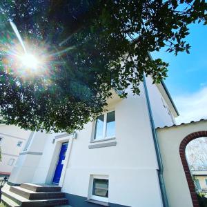 een wit huis met een blauwe deur en een trap bij DAS STRANDGLÜCK - Villa und Mee(h)r in Graal-Müritz