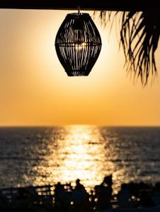a chandelier hanging over the ocean at sunset at Sunset Studios & Rooms in Antiparos