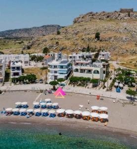 a group of umbrellas and cars on a beach at Joanna Apartments in Haraki