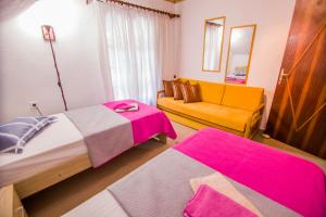 een hotelkamer met twee bedden en een bank bij villa Touzla in Ofrínion