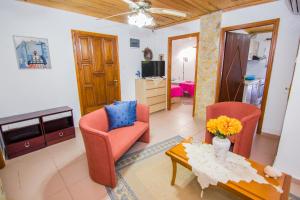 een woonkamer met twee stoelen en een tafel bij villa Touzla in Ofrínion