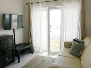カルヴォエイロにあるAurorasol Carvoeiro Beach Apartmentのリビングルーム(ソファ、テレビ付)
