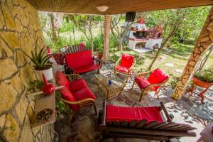 奧福里尼翁的住宿－villa Touzla，一个带红色椅子和石墙的庭院