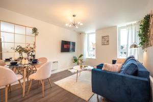 a living room with a blue couch and a table at Best Price - Contact us -Cityscape Beautiful Apartment in the Heart of the Action in Southampton