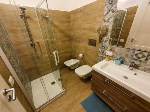 een badkamer met een douche, een toilet en een wastafel bij GE Suite in Catania