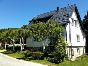 een wit huis met een zwart dak bij Guest House Lipov Hlad in Plitvička Jezera