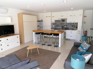a kitchen with white cabinets and a bar with stools at Villa Casa Tranquilespiral Alcobaça-Nazare in Mendalvo