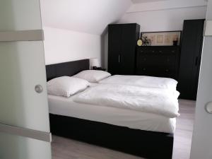 - une chambre avec un lit doté de draps et d'oreillers blancs dans l'établissement Ferienhaus Resit 1, à Steinhude