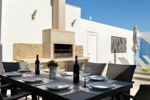 a black table with wine bottles and glasses on a patio at Villa Tropicana in Albufeira