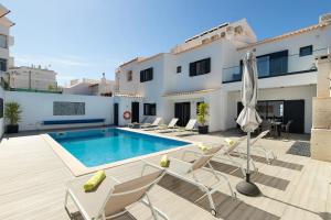 a villa with a swimming pool and patio furniture at Villa Tropicana in Albufeira