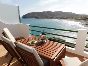 einen Holztisch auf einem Balkon mit Meerblick in der Unterkunft Casa Marina in Las Playitas