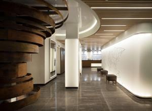 a hallway with chairs and a staircase in a building at NH Madrid Chamberí in Madrid