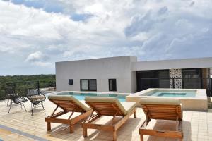 a patio with two chairs and a swimming pool at Sessile Tulum by The Spot Rentals in Tulum