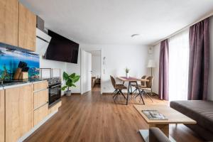 a living room with a kitchen and a table at Amelies Mountain View in Kaprun