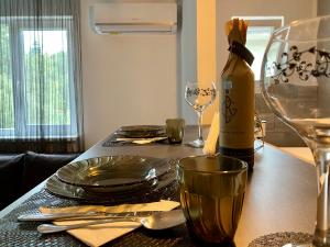 un tavolo con un piatto e una bottiglia di vino di T&T Apartman a Praid