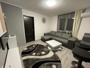 un soggiorno con divano e tavolo di T&T Apartman a Praid
