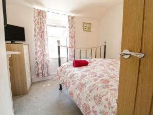 a bedroom with a bed with a red pillow on it at 6 Smithfield Lane in Dolgellau