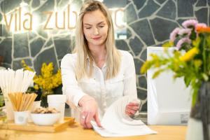 a woman sitting at a table in a flower shop at Apartmán Vila Zuberec in Zuberec