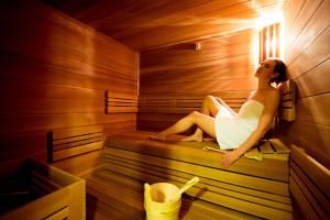 uma mulher sentada no interior de uma sauna em Villa Aurelie em Velké Losiny