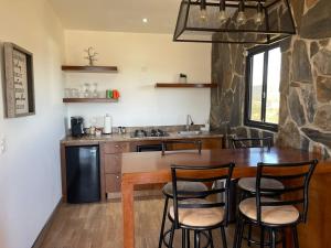 a kitchen with a table, chairs and a refrigerator at Siempre Valle in Valle de Guadalupe